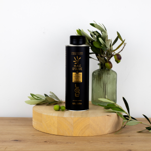 Bouteille d'huile d'olive à la truffe noire de Maison Leydier, aromatisée, sur fond naturel avec olives fraîches et branches d'olivier. Produit culinaire de qualité, fabriqué en France.