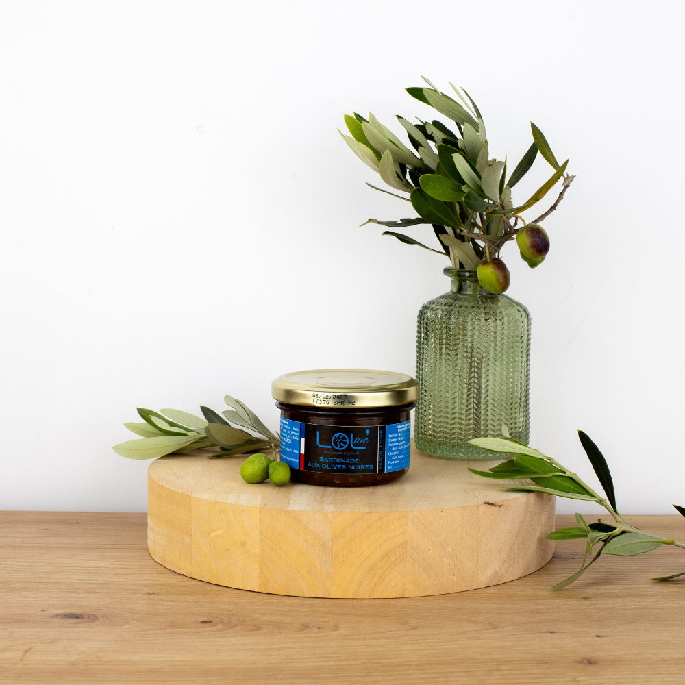 Pot de sardines aux olives noires de Maison Leydier, sur fond naturel avec olives fraîches et branches d'olivier. Produit artisanal de qualité, fabriqué en France.